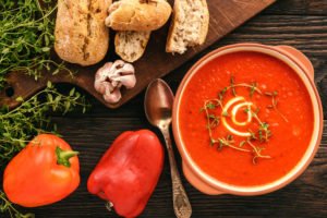 bread, paprika, tomato soup neatly arranged on a table