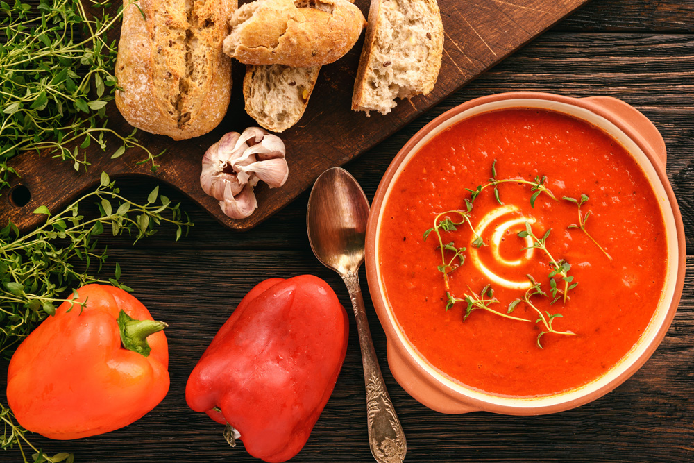 bread, paprika, tomato soup neatly arranged on a table